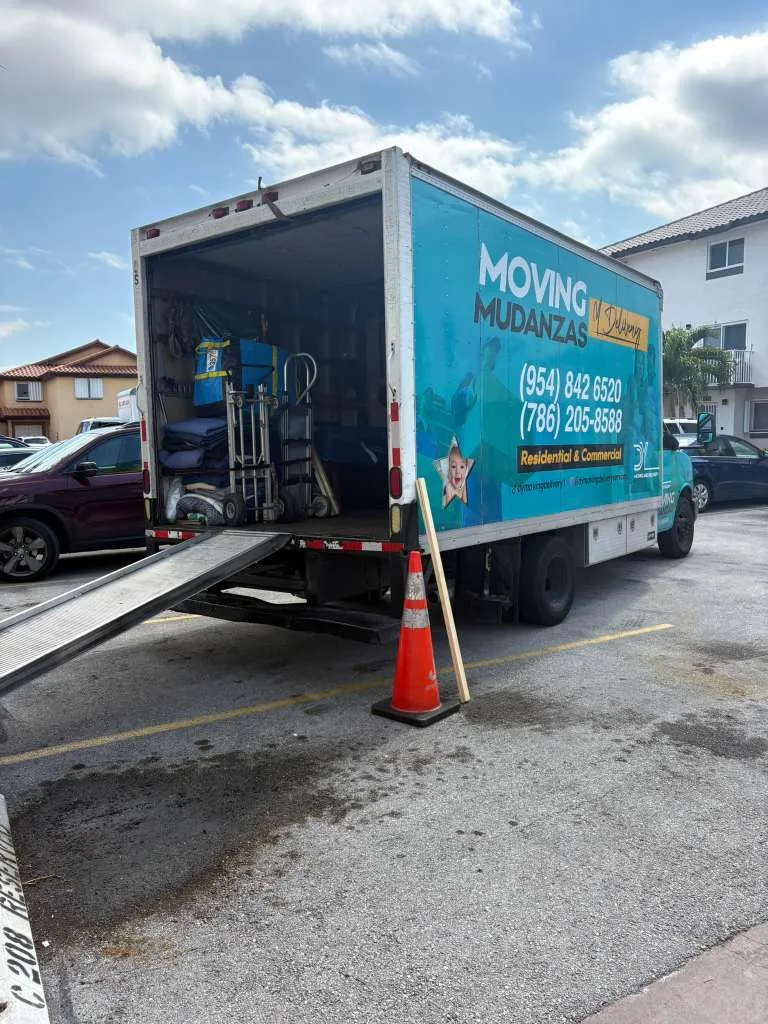 DY Moving & Delivery branded teal box truck with loading ramp and phone numbers