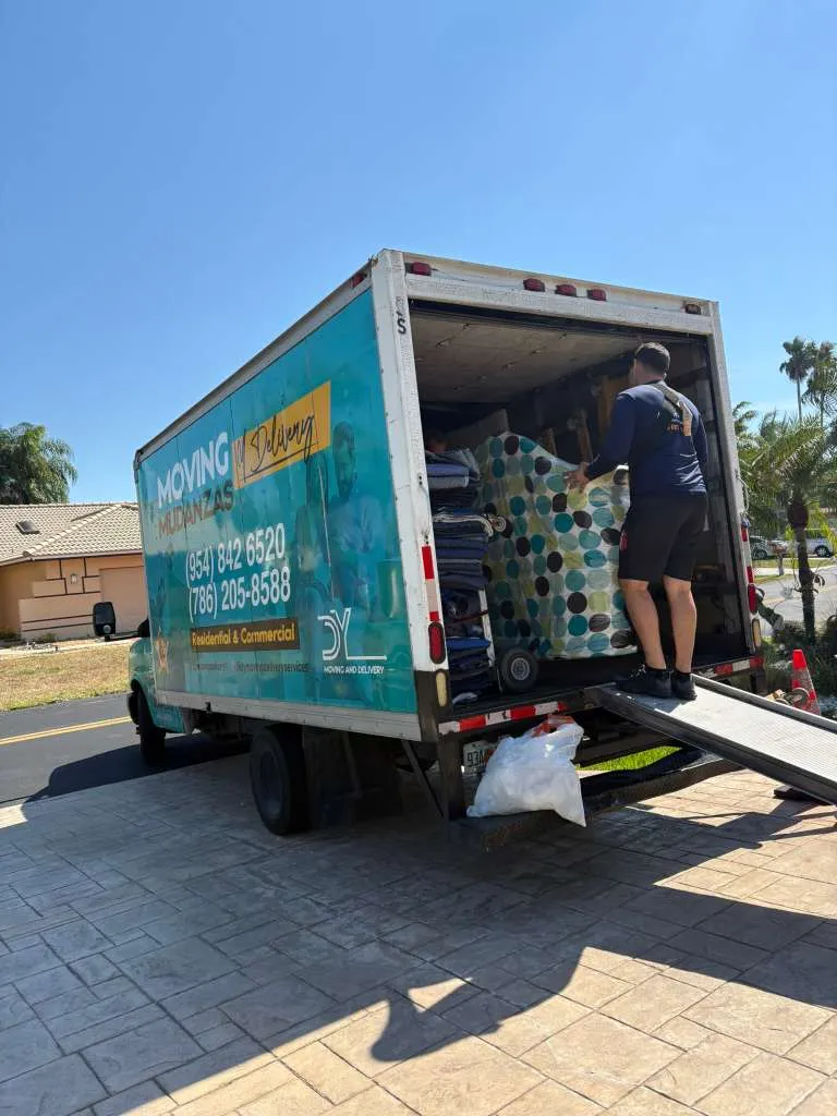 DY Moving & Delivery branded box truck being loaded by a mover